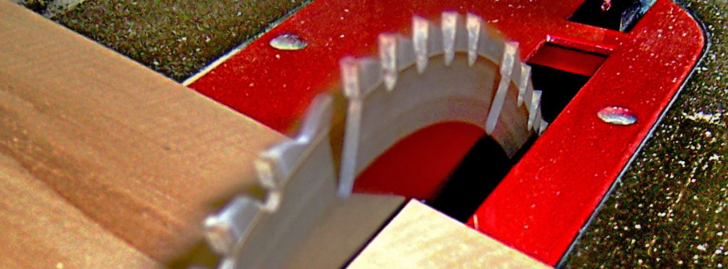 Extreme close-up of a table saw blade cutting through a piece of lumber