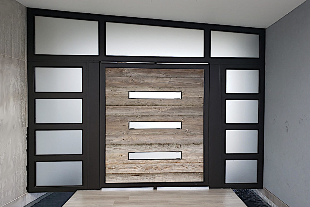 A contemporary style entry with contrasting colored wood and frosted glass panels